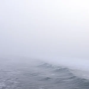 Thick fog rolling over the shoreline of Lake Michigan.