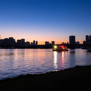 View of the Detroit River with Riverside Park in the foreground at dusk.