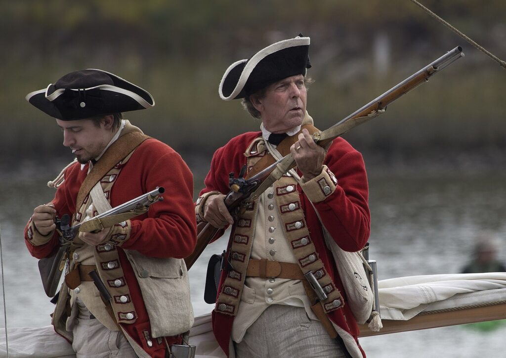Reenactors in Revolutionary War-era uniforms with muskets