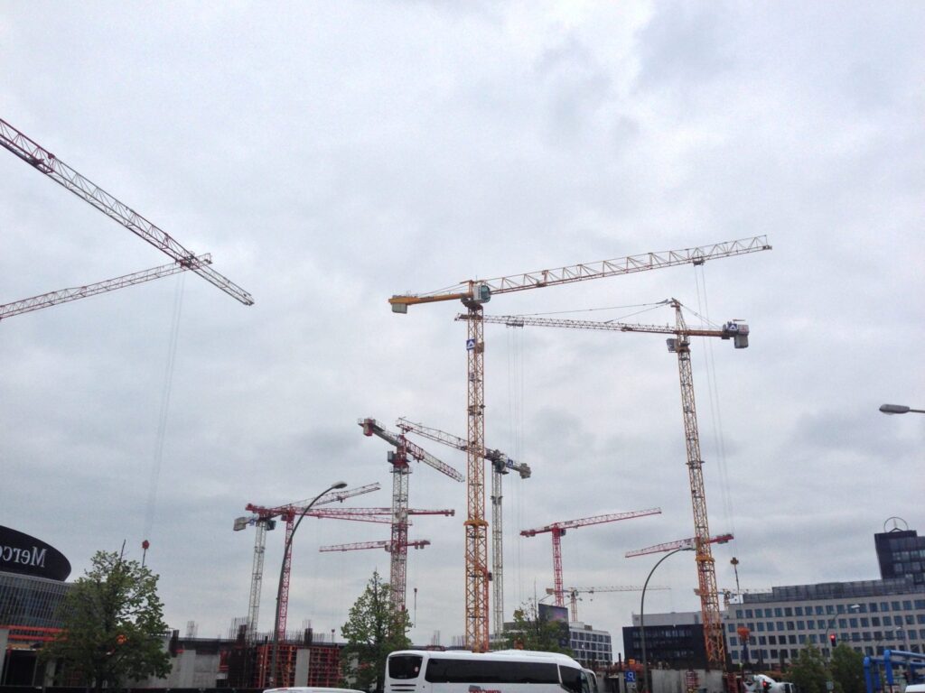 Several construction cranes against the sky